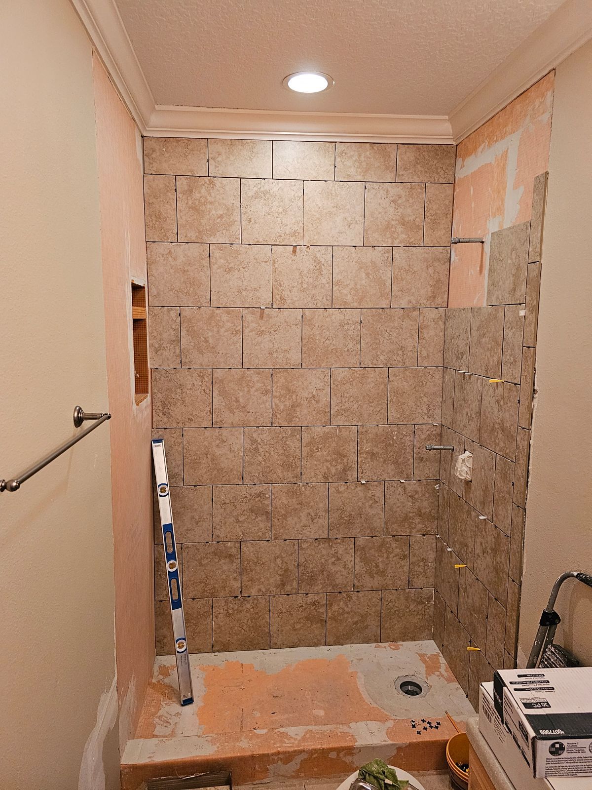 A bathroom with a tiled wall and a ladder.