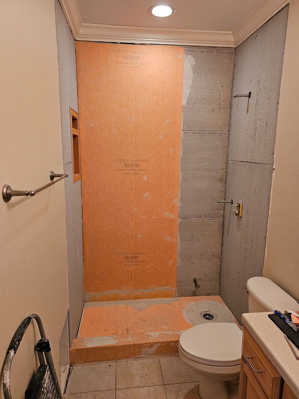 A bathroom with a toilet and a shower being remodeled.