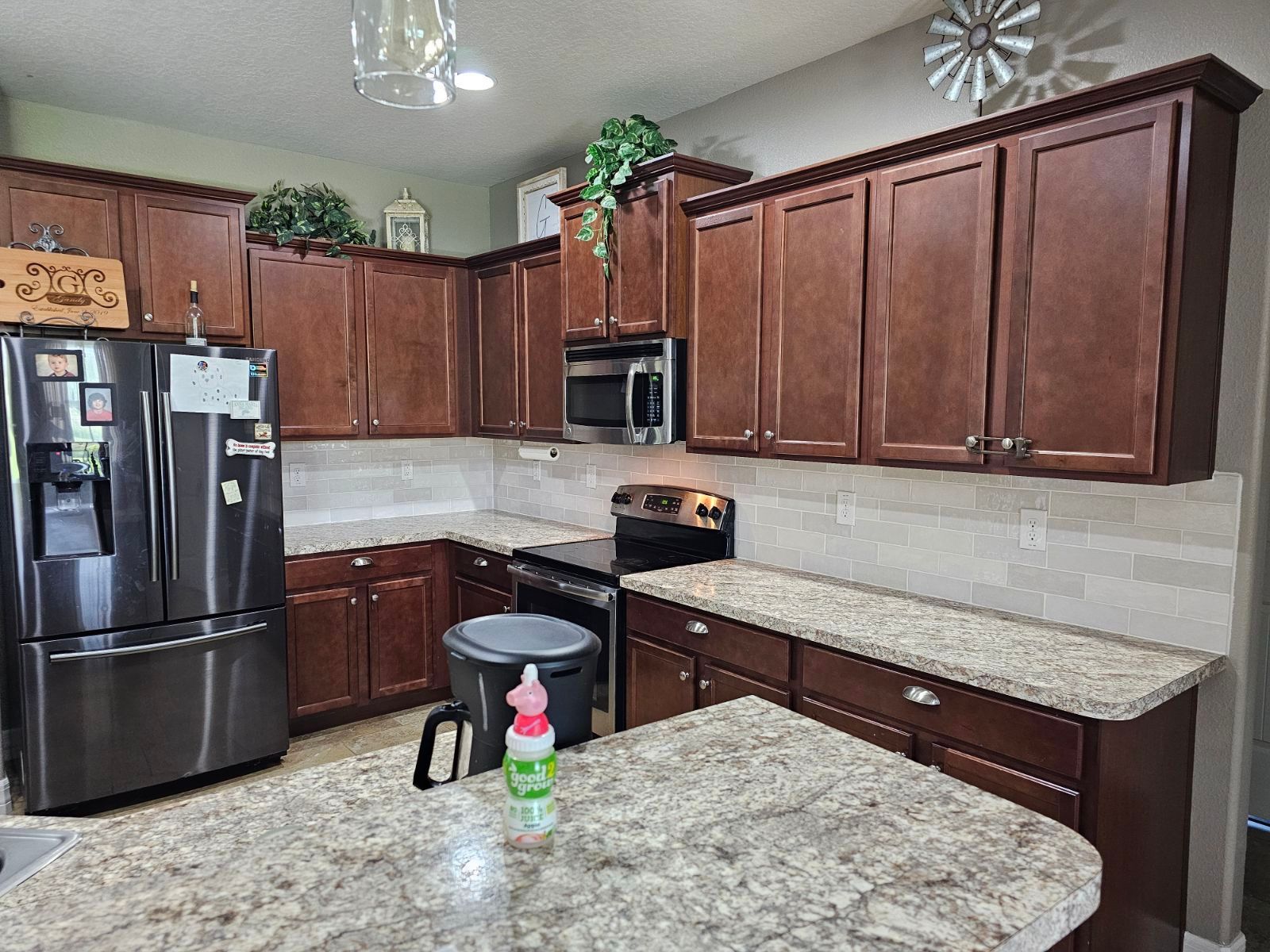 A kitchen with stainless steel appliances , granite counter tops , and wooden cabinets.
