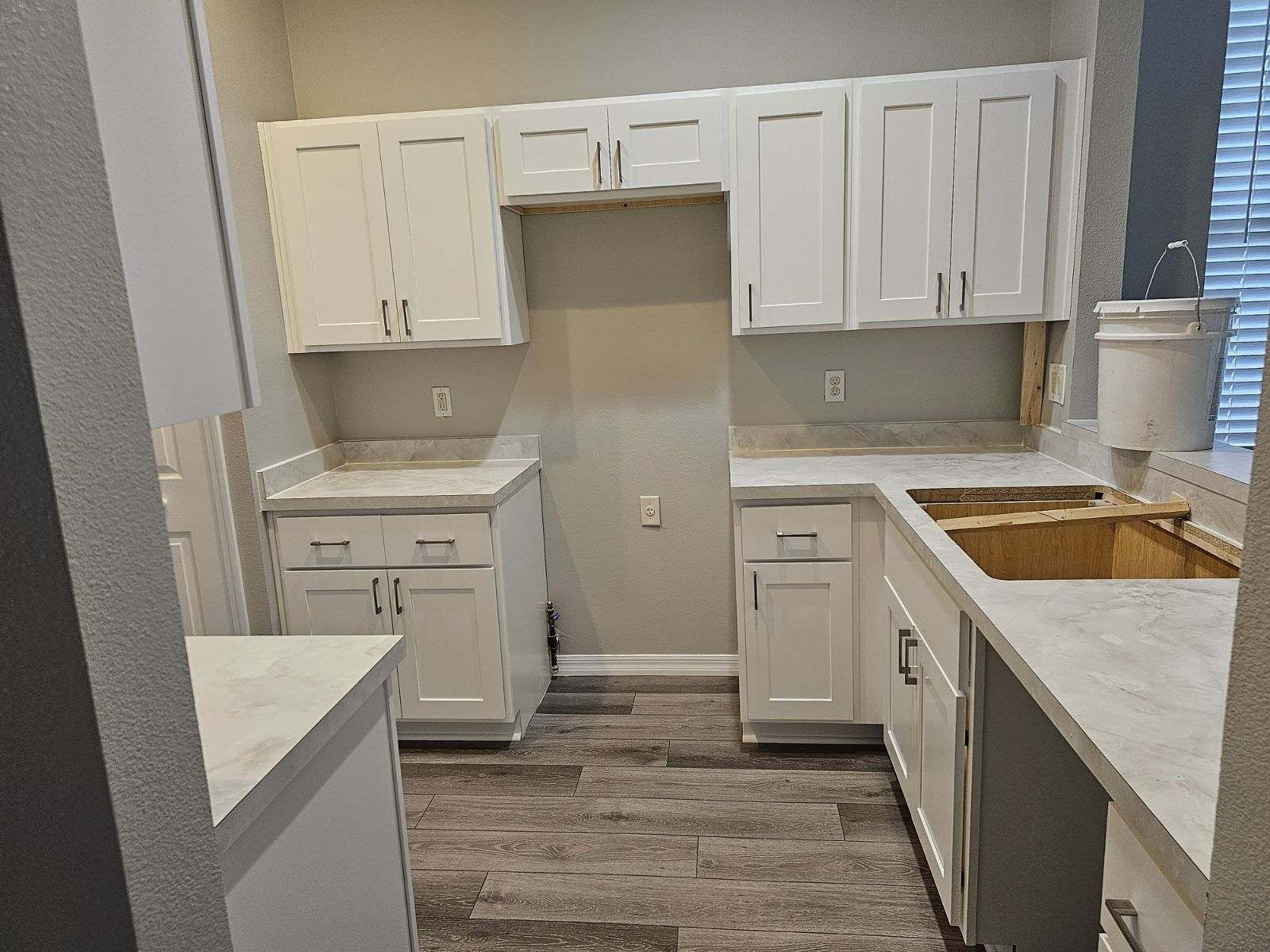 A kitchen with white cabinets and a sink.