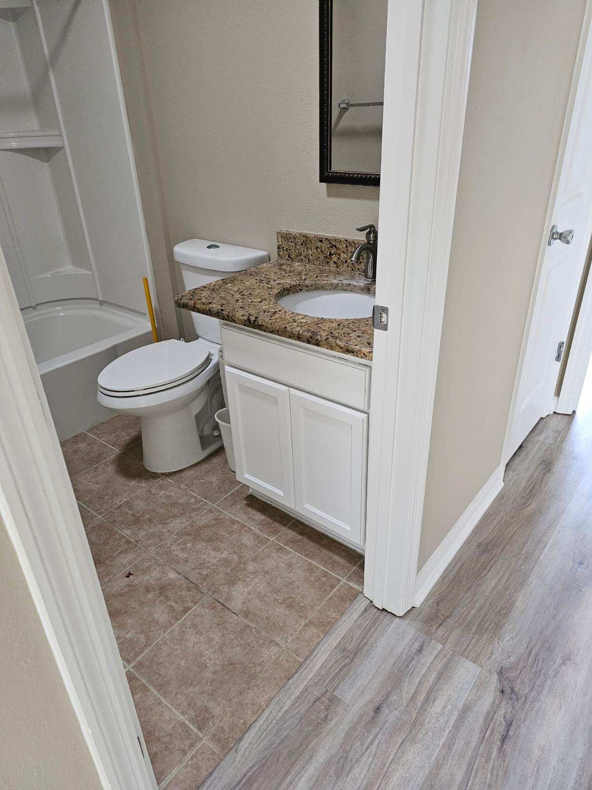 A bathroom with a toilet , sink , and bathtub.