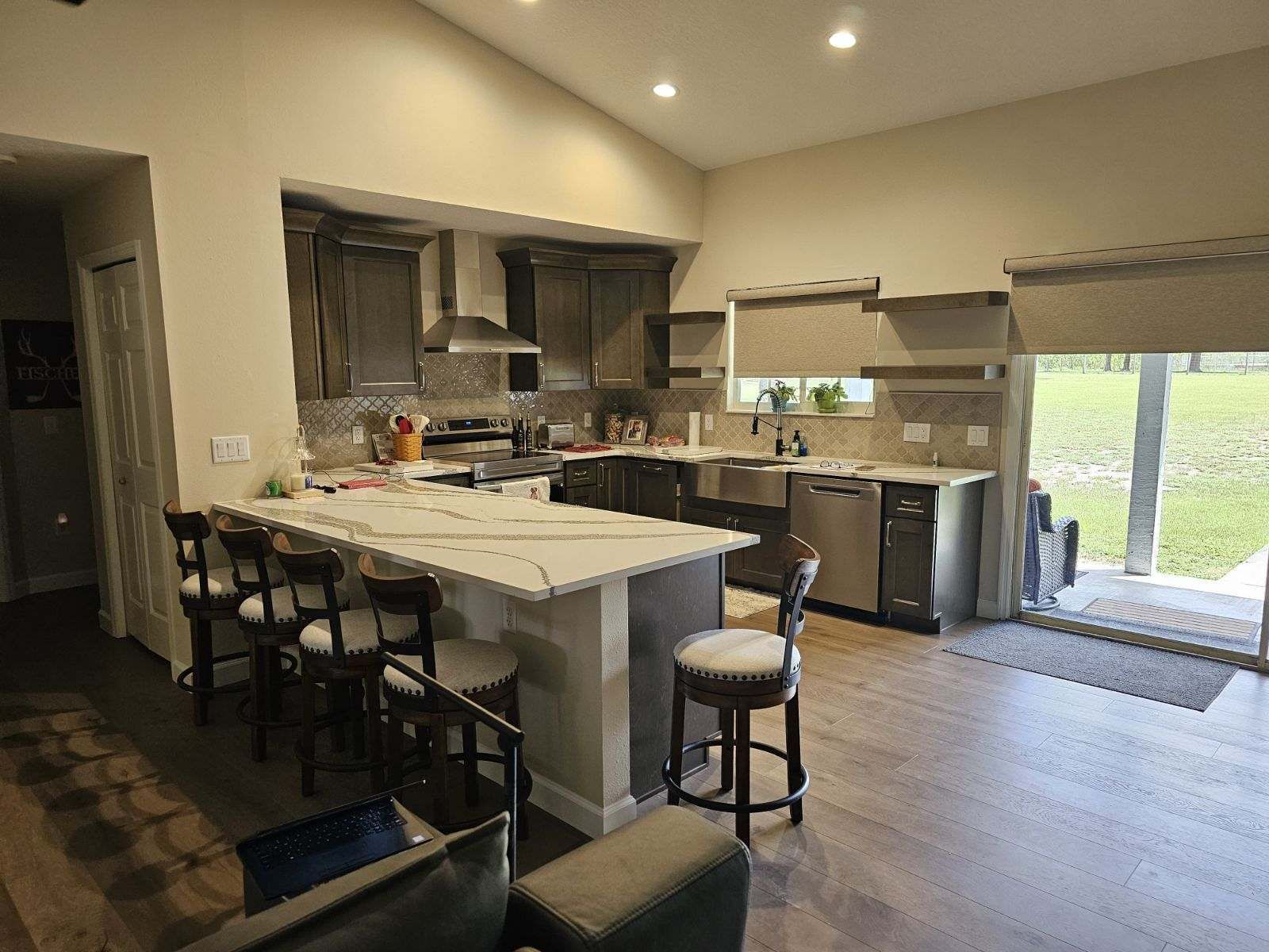 A kitchen with a large island and stainless steel appliances in a house.