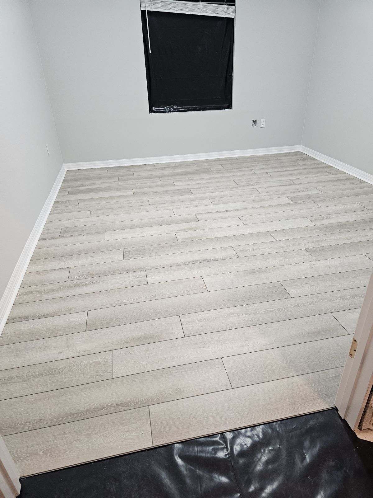 A room with a wooden floor and a window.