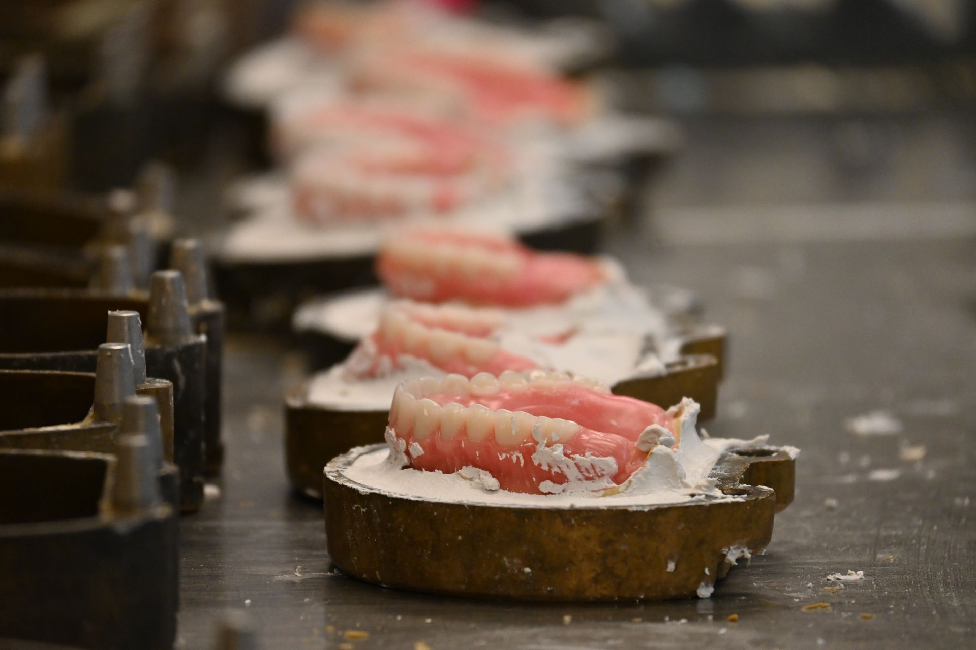a row of dentures are lined up on a table at summit-horizon dental lab