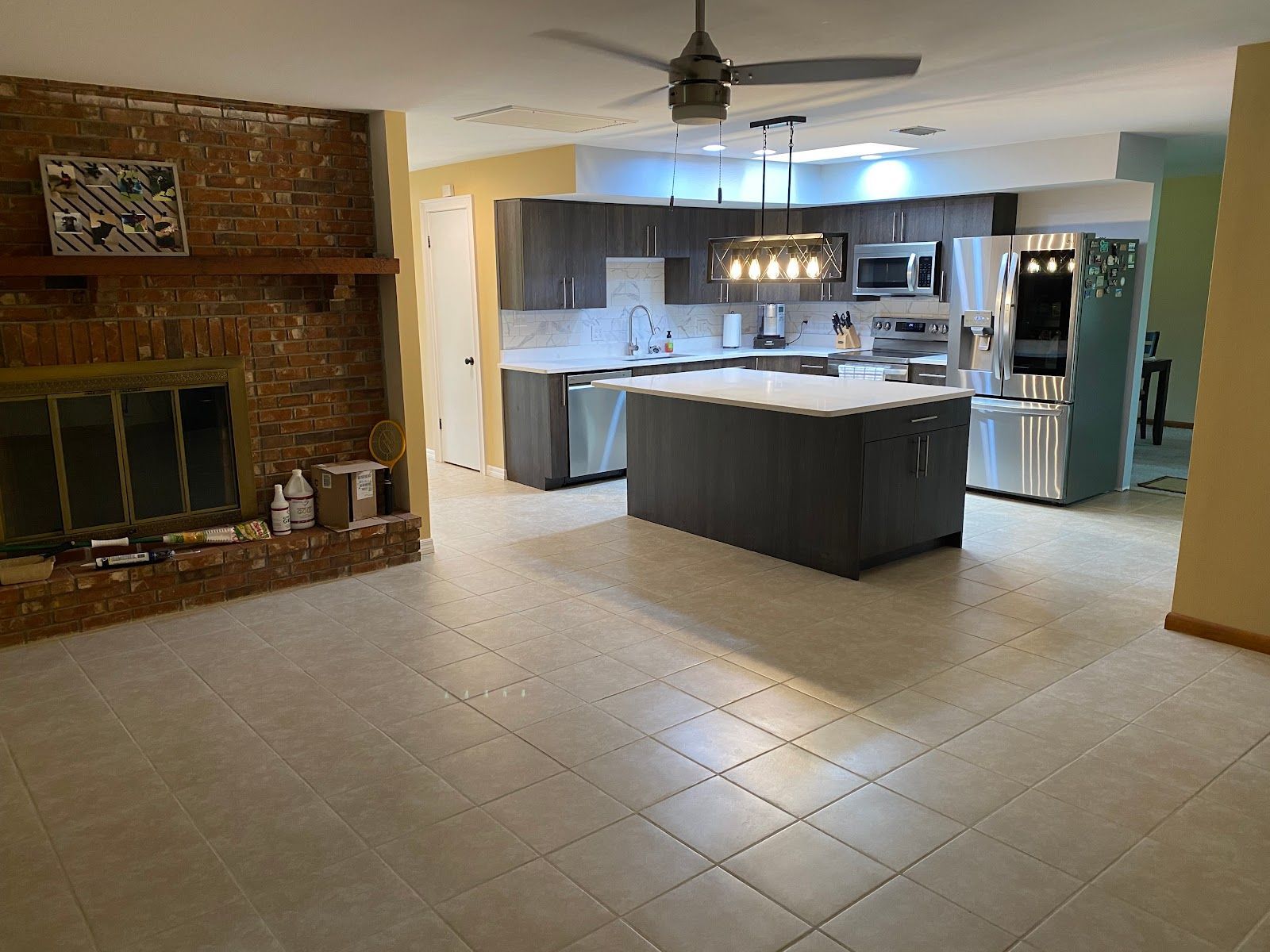 A kitchen with a large island and a ceiling fan.