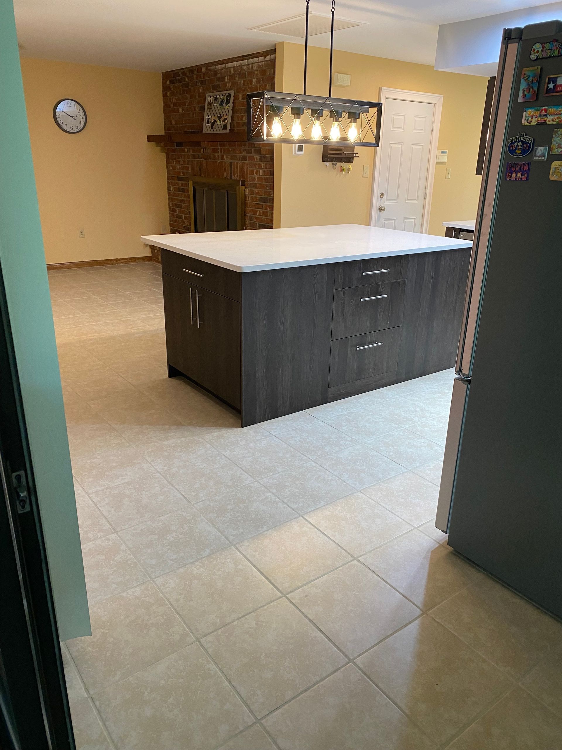 A person is applying grout to a tile floor with a trowel.