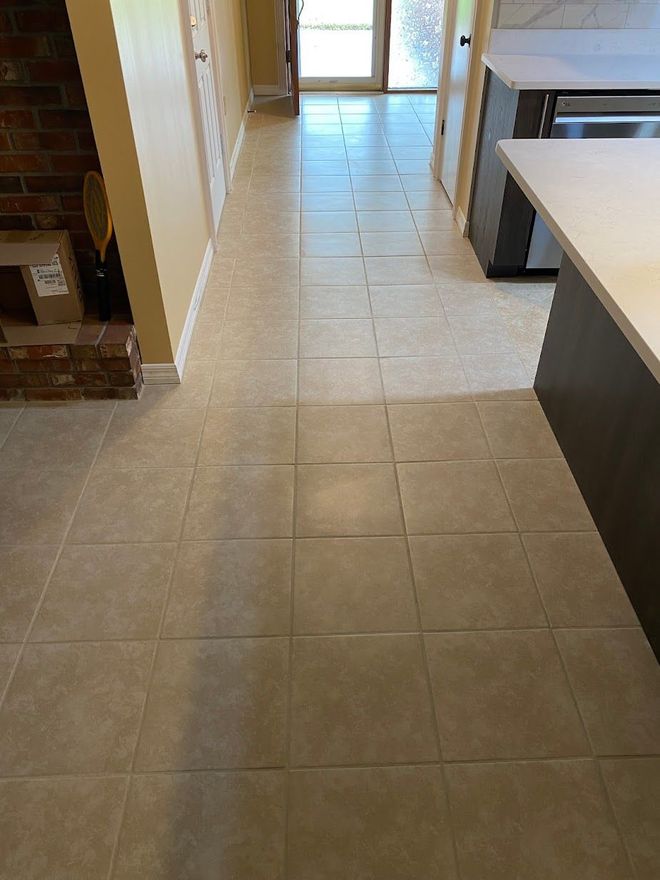 A kitchen with a tiled floor and a brick fireplace.