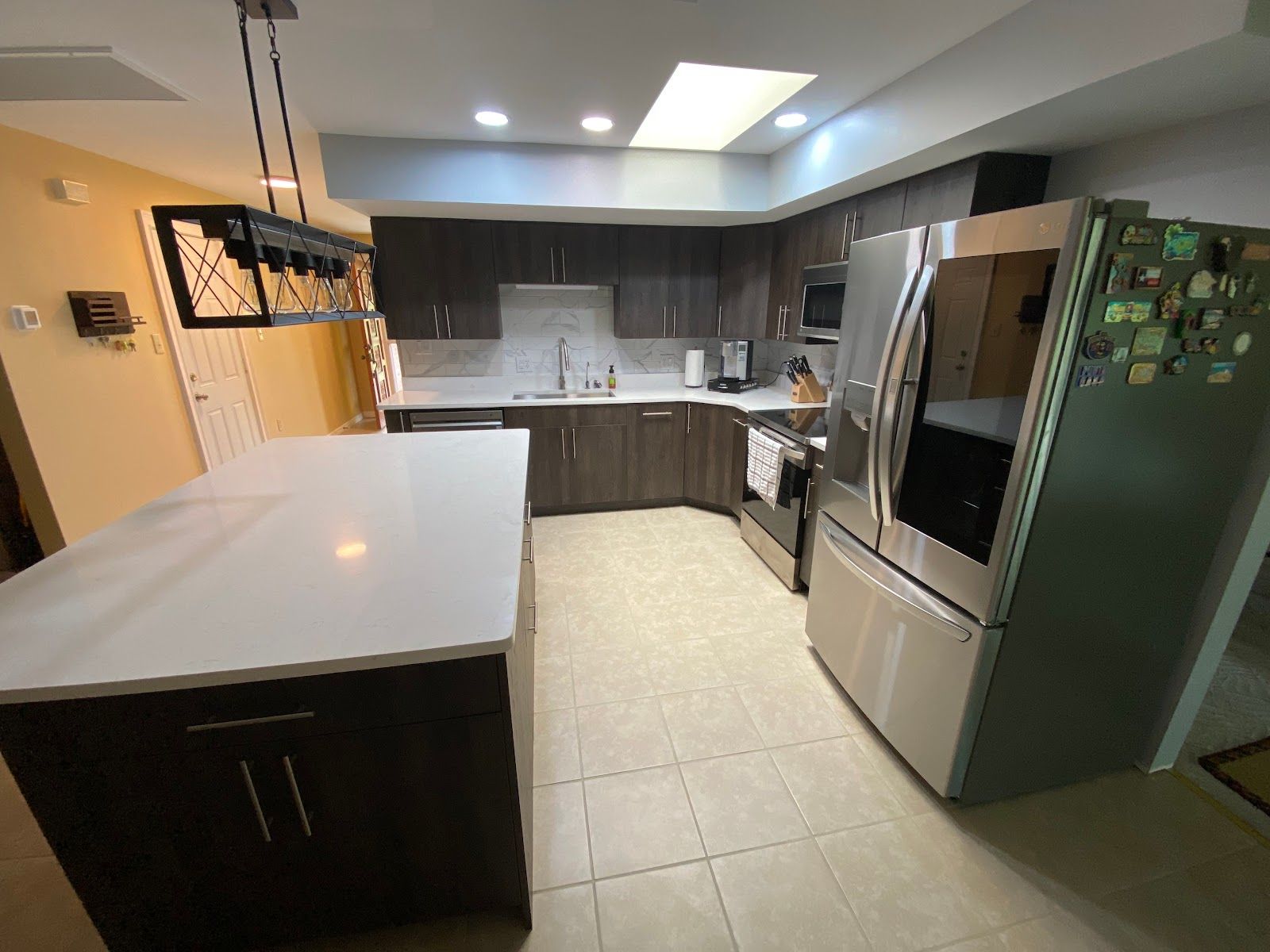 A kitchen with stainless steel appliances and a large island.
