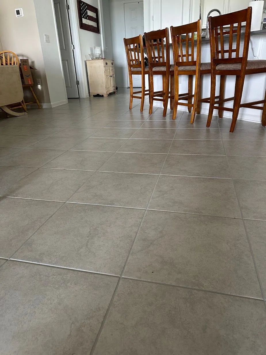 Empty dining room with wooden chairs and table on a tiled floor
