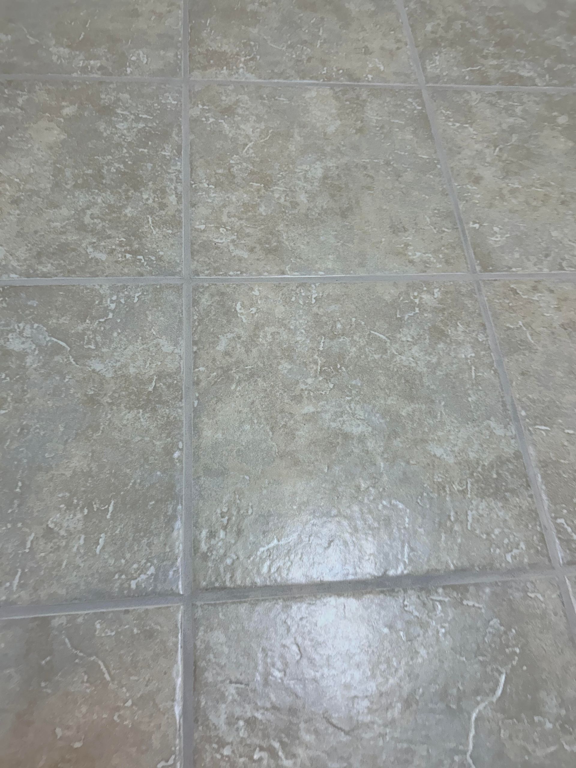 White tiled shower wall with gray grout.