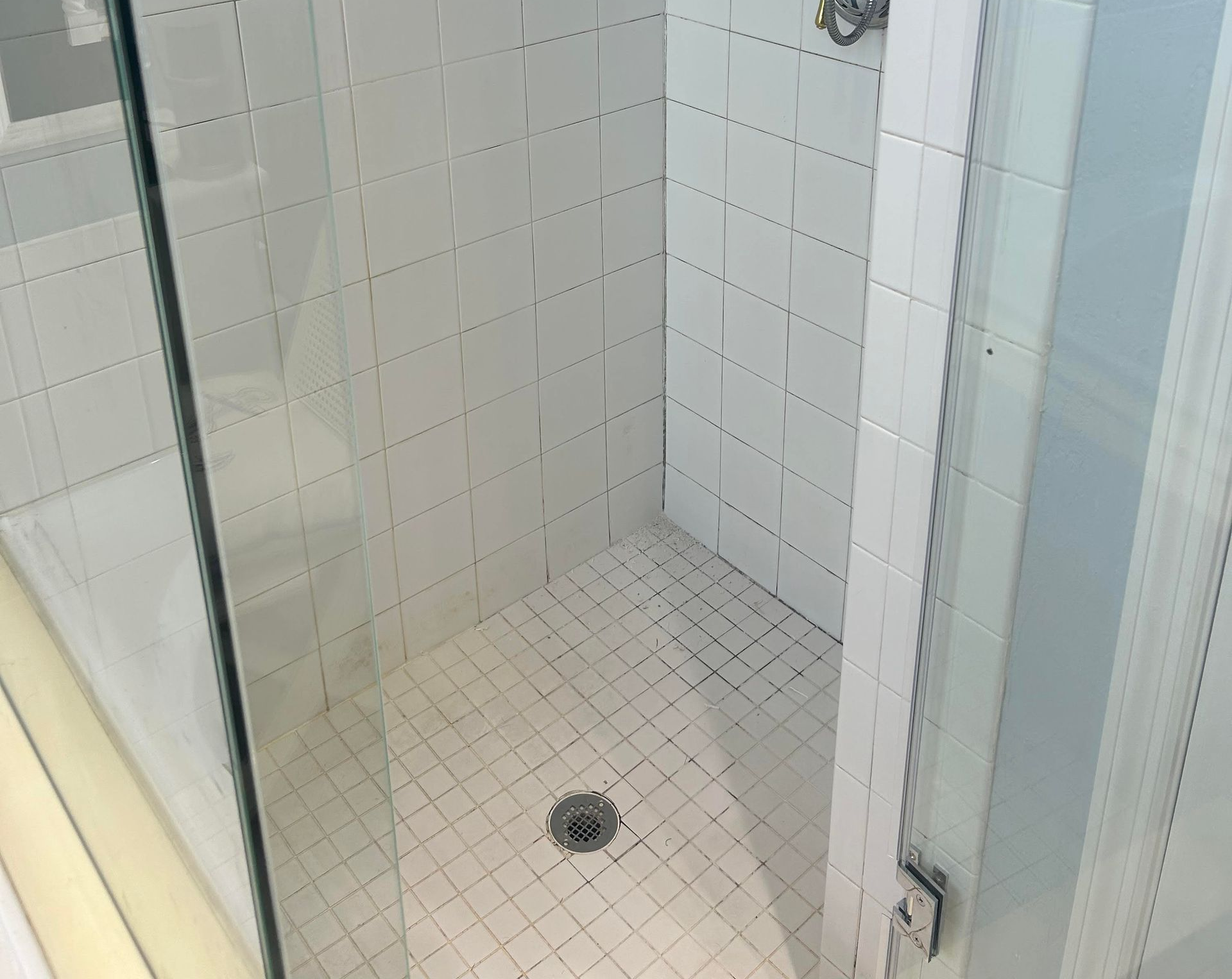 A close up of a tiled floor in a bathroom next to a toilet.