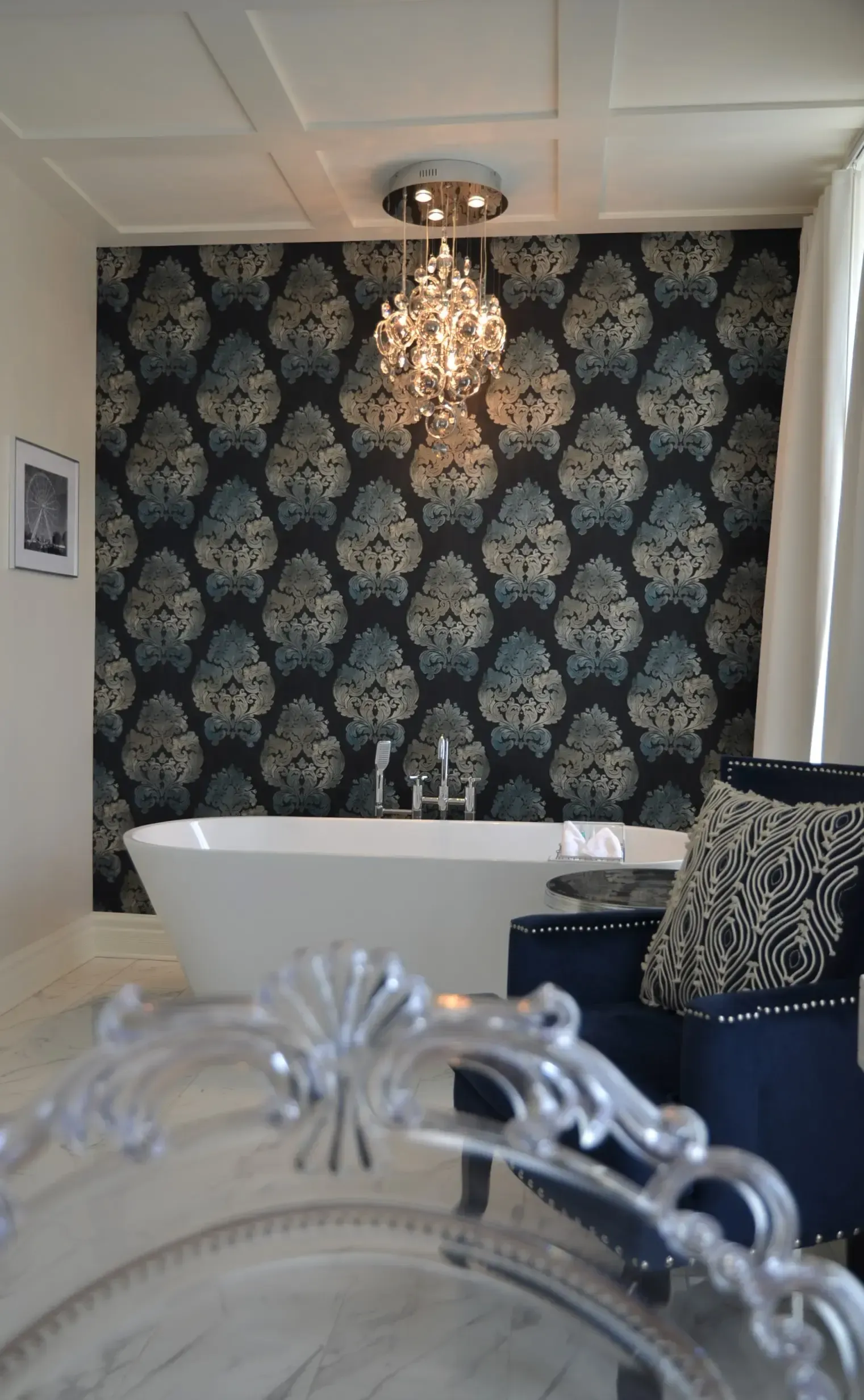 Une salle de bain avec une baignoire une chaise et un lustre