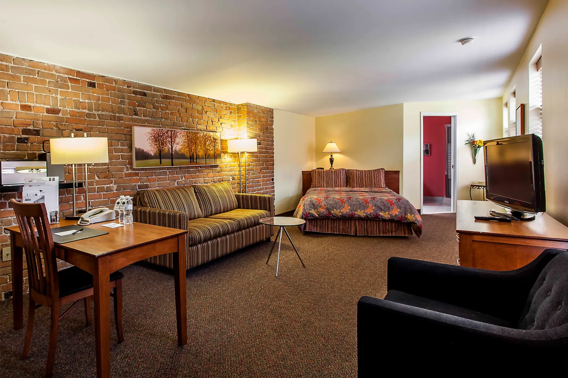 Une chambre d'hôtel avec un grand lit, un canapé, une table et des chaises
