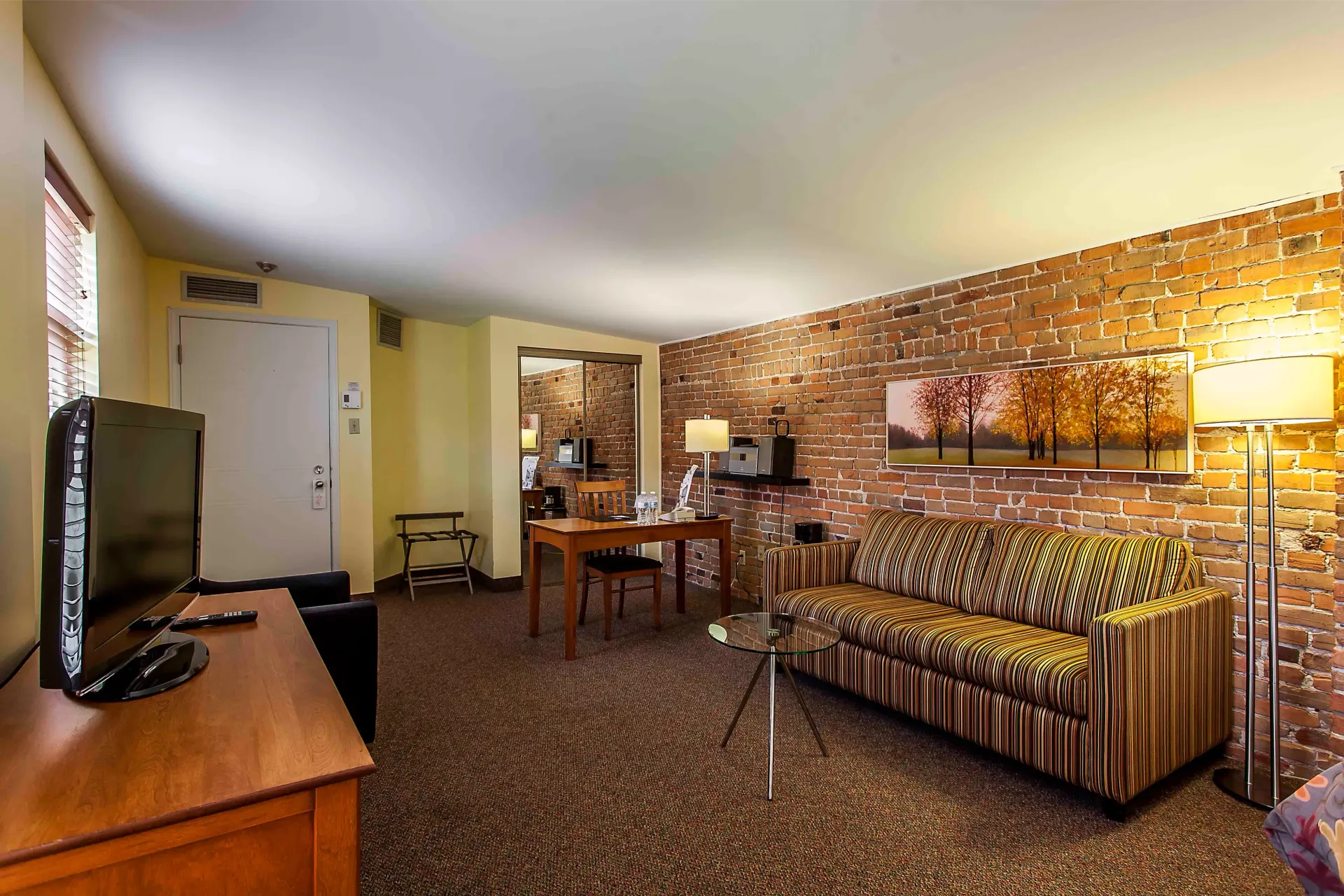 Une chambre d'hôtel avec un canapé, une table et une télévision