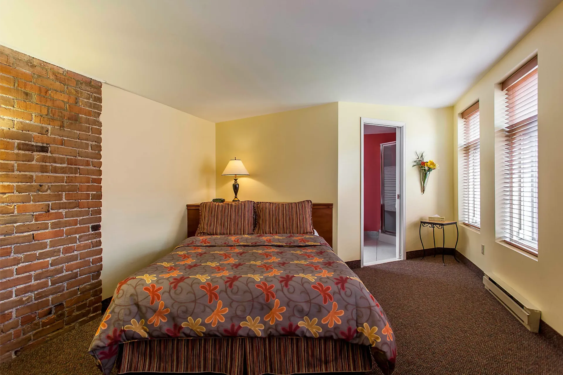 Une chambre d'hôtel avec un lit et un mur de briques