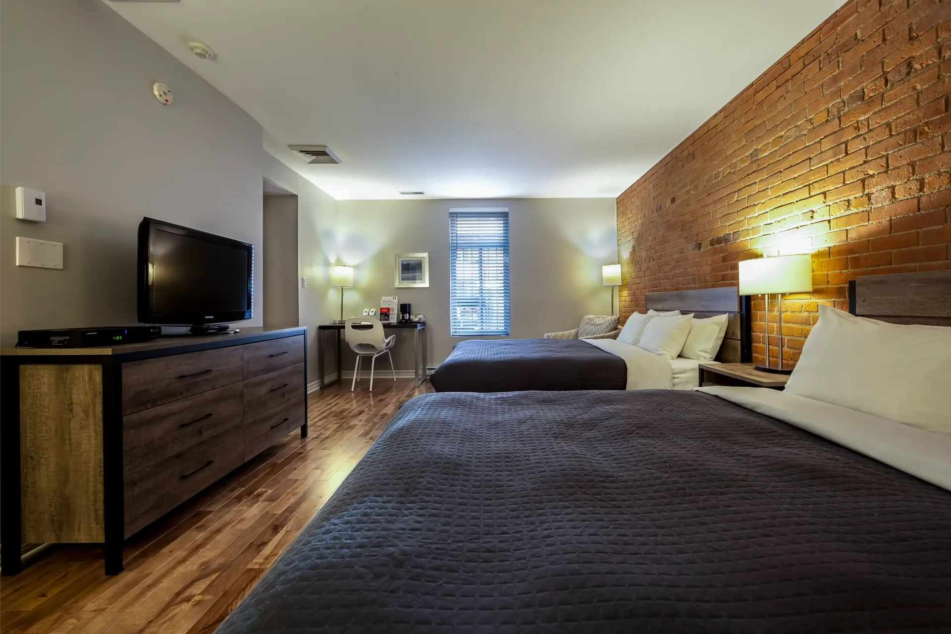 Une chambre d'hôtel avec deux lits et une télévision à écran plat.