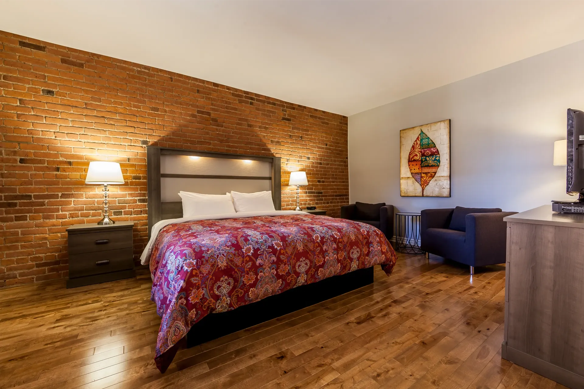 Une chambre d'hôtel avec un grand lit et un mur de briques