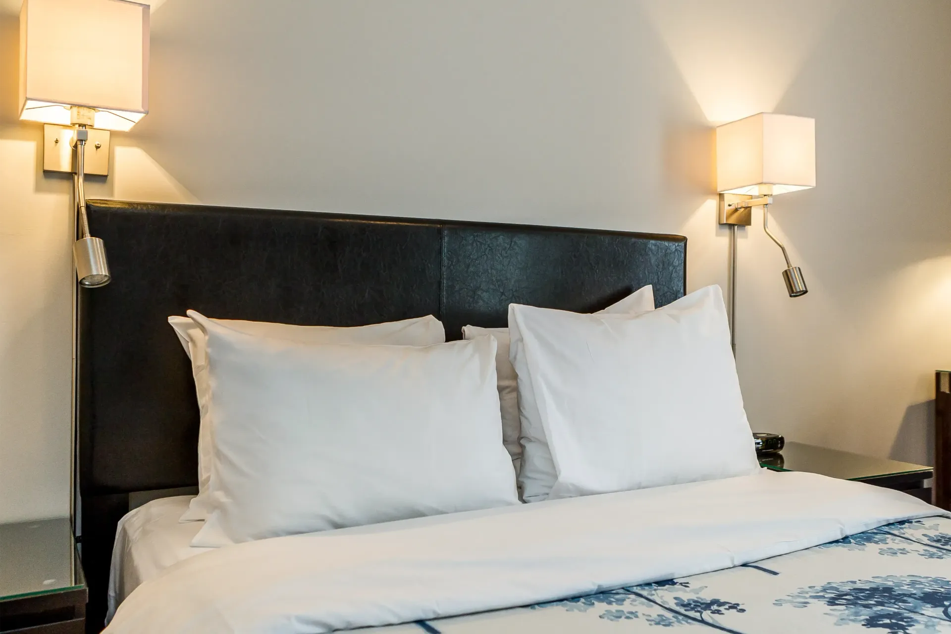 Un lit avec des draps blancs et des oreillers dans une chambre d'hôtel
