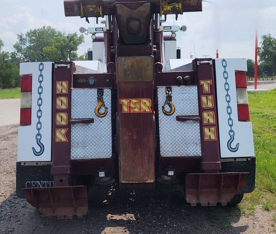 A brown and white tow truck with the letters tsr on the back