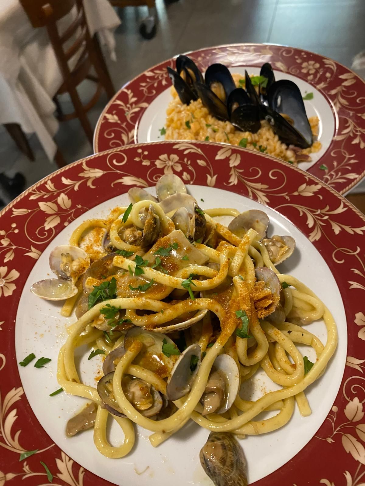 Esposizione di pesce fresco su ghiaccio con limoni e vegetazione decorativa.