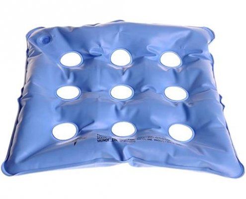 A blue cushion with holes in it on a white background.