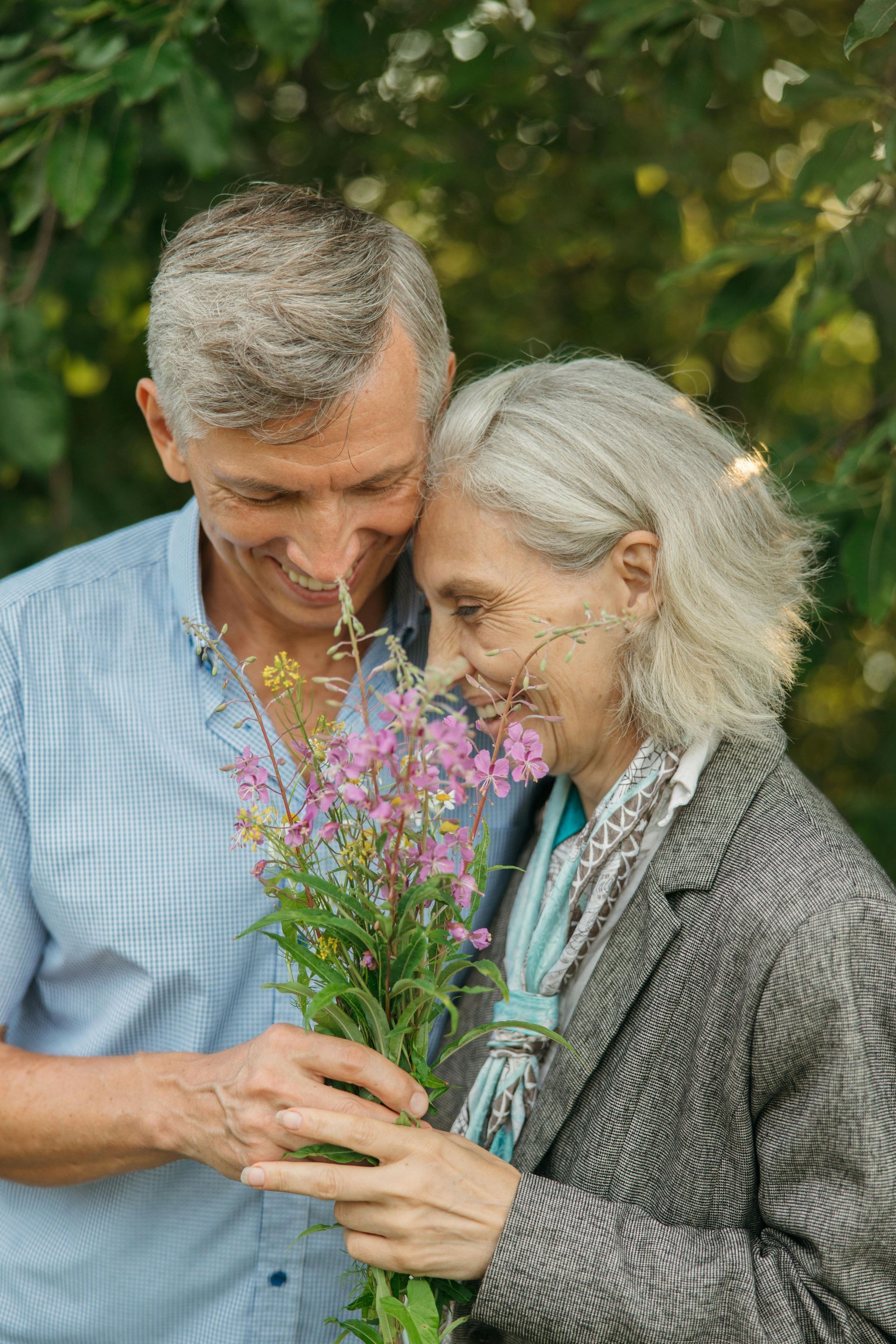 A man is giving a woman a bouquet of flowers.