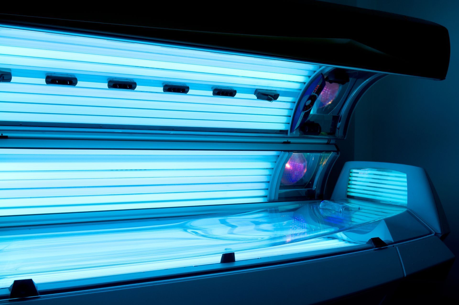 Tanning bed with bright blue UV lights; interior view.