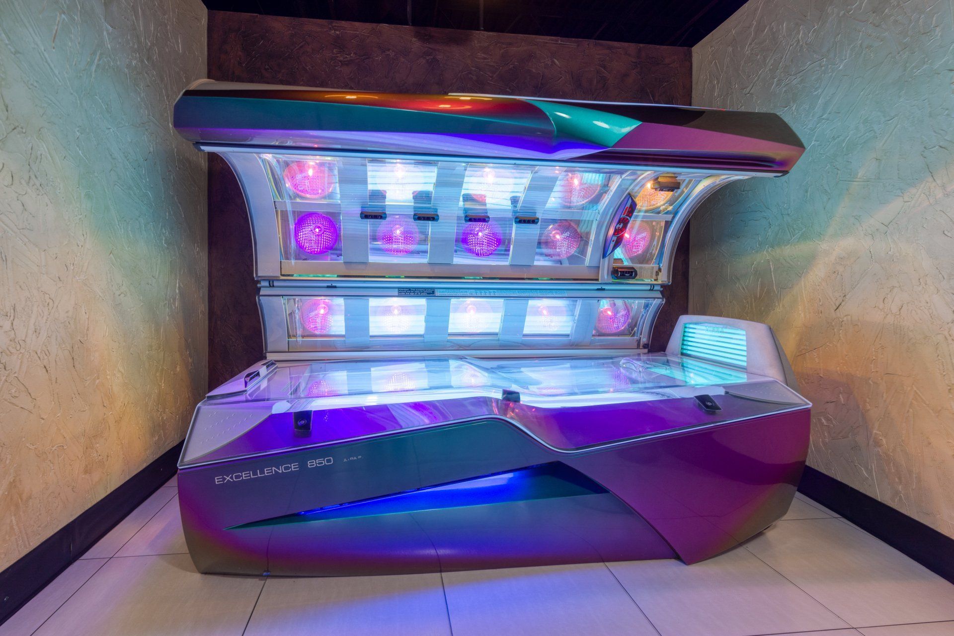 Tanning bed with purple and teal accents, in a tanning salon.