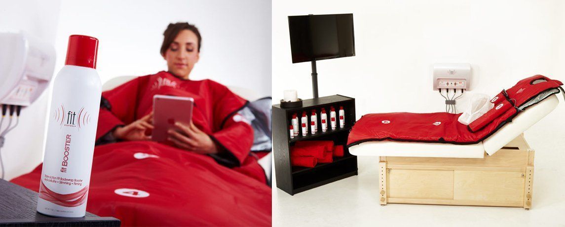Woman in red treatment wrap using a tablet. Treatment bed with black screen and supplies.