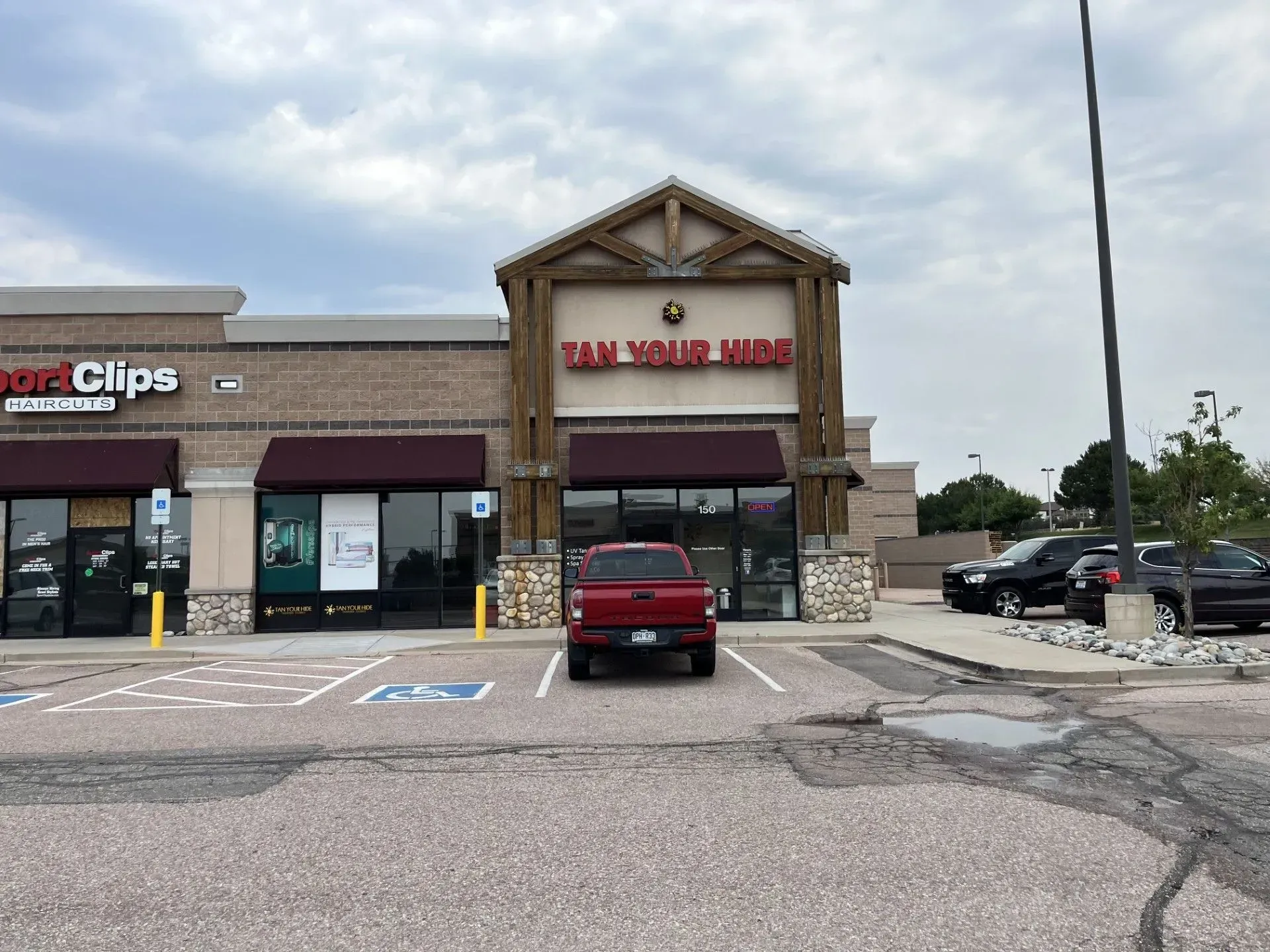 Exterior of a strip mall with a tan building that reads 