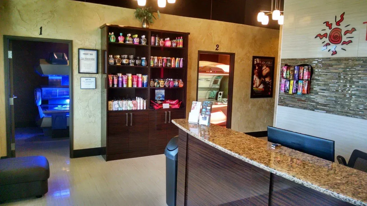 Lobby with a reception desk, product shelves, and doorways. Warm tones.