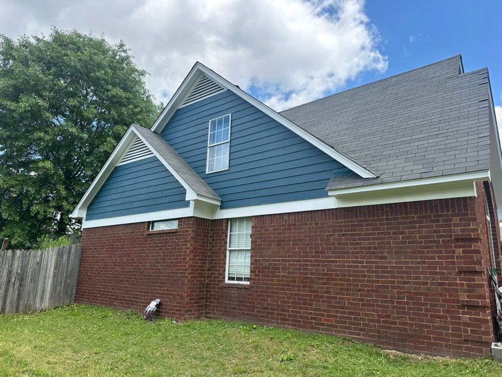 A brick house with a blue siding and a gray roof.