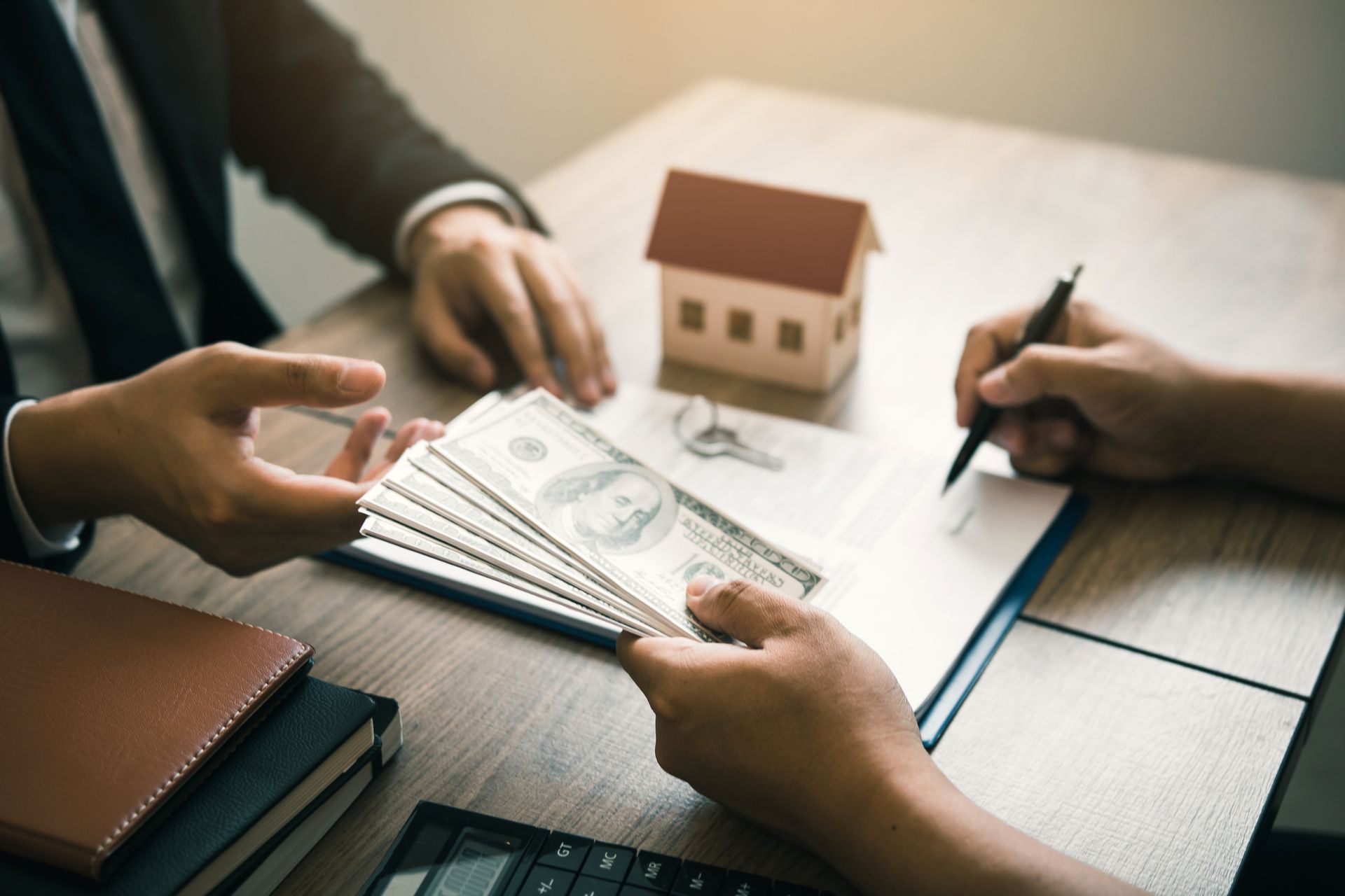 landlord and tenant reviewing financial documents at a desk, with a calculator and pen visible