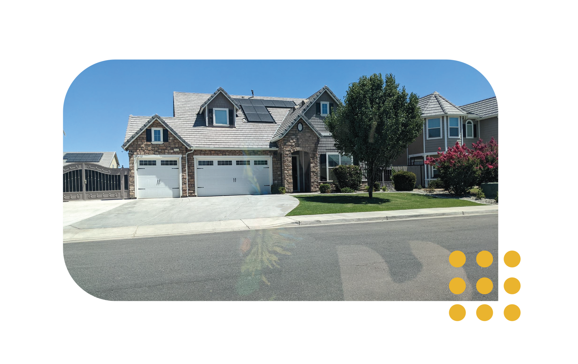 A two-story suburban house with a stone facade, a two-car garage, solar panels on the roof, and a front yard with a tree.