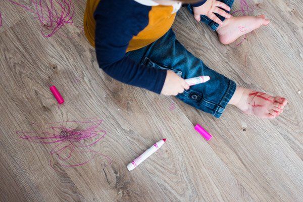 kid playing with marker on floor