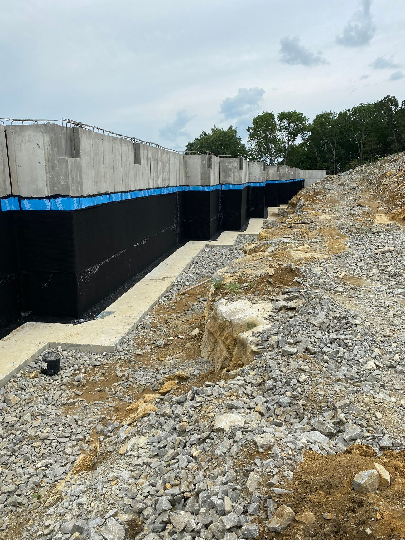 A concrete wall is being built on top of a pile of rocks.