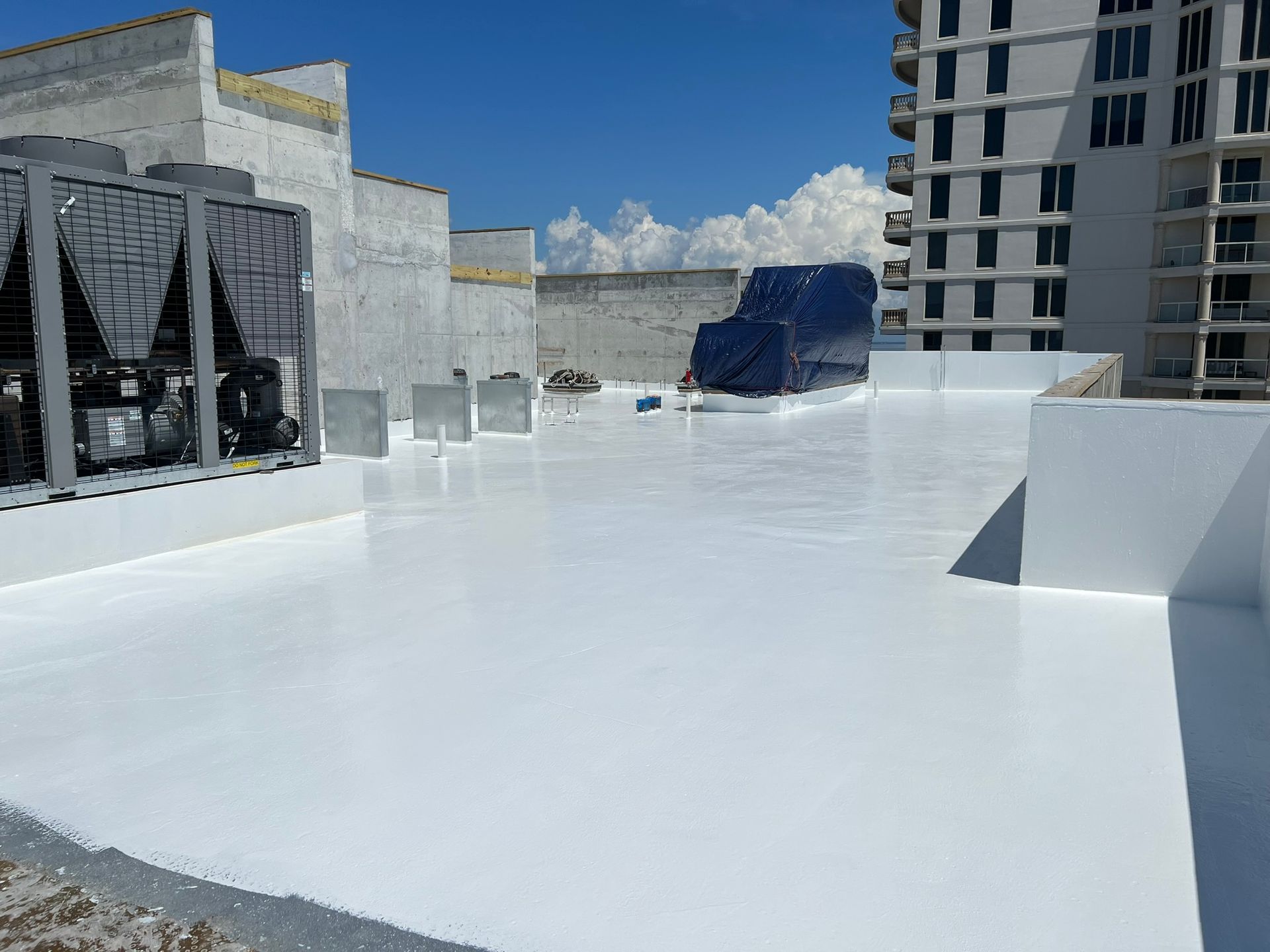 A large white roof with a lot of buildings in the background.
