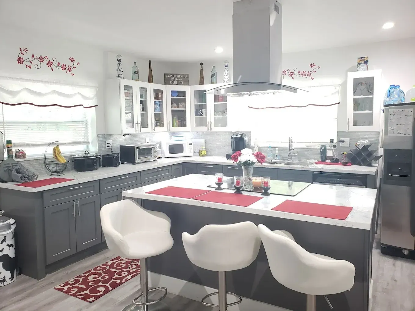 A kitchen with gray cabinets and white counter tops
