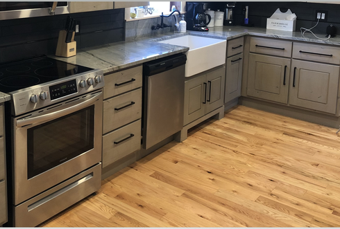 A kitchen with stainless steel appliances and wooden floors