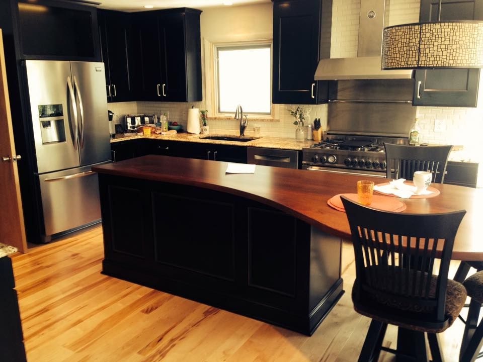 A kitchen with black cabinets and stainless steel appliances