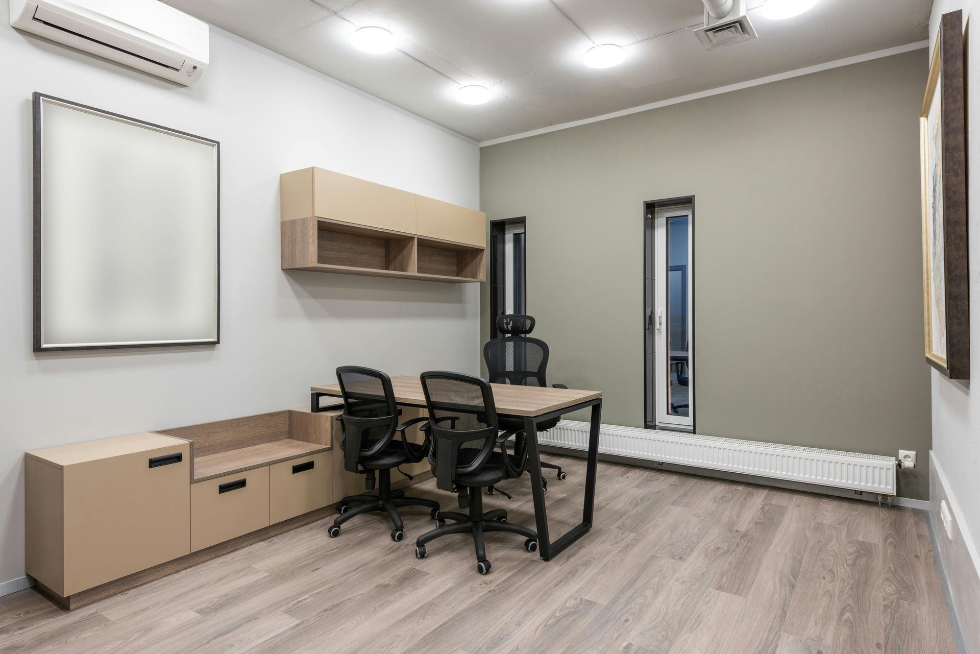 A conference room with a table and chairs and a whiteboard on the wall.