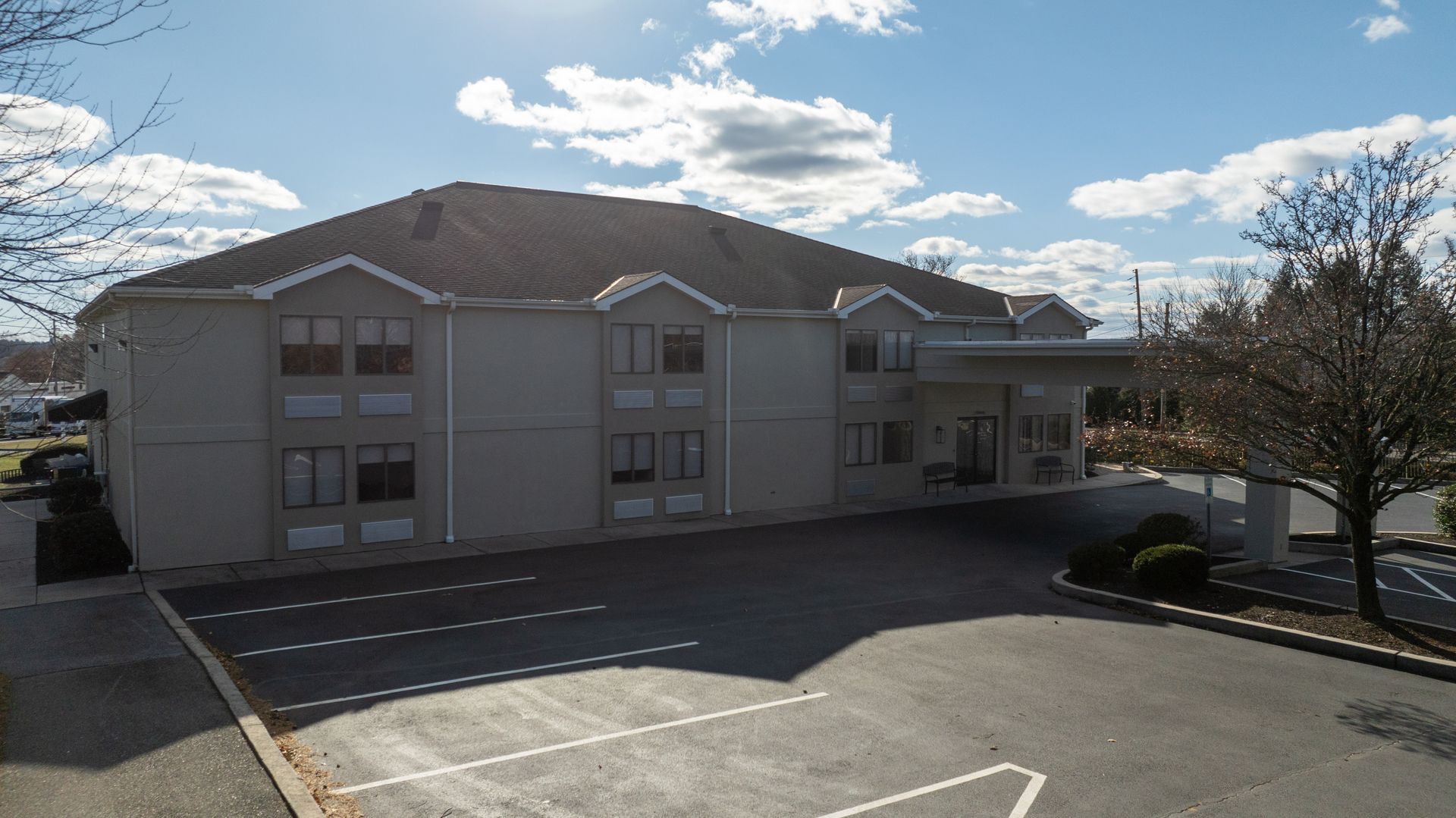 A large white building with a parking lot in front of it