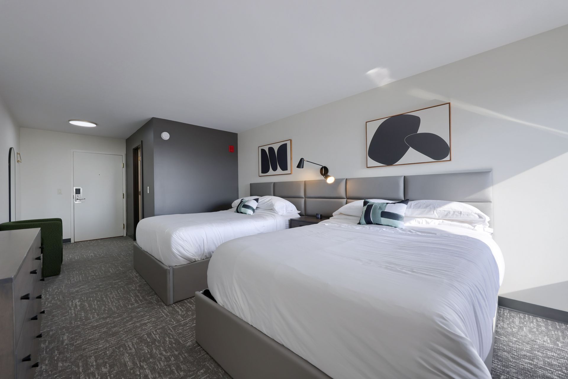 A hotel room with two beds and a dresser.