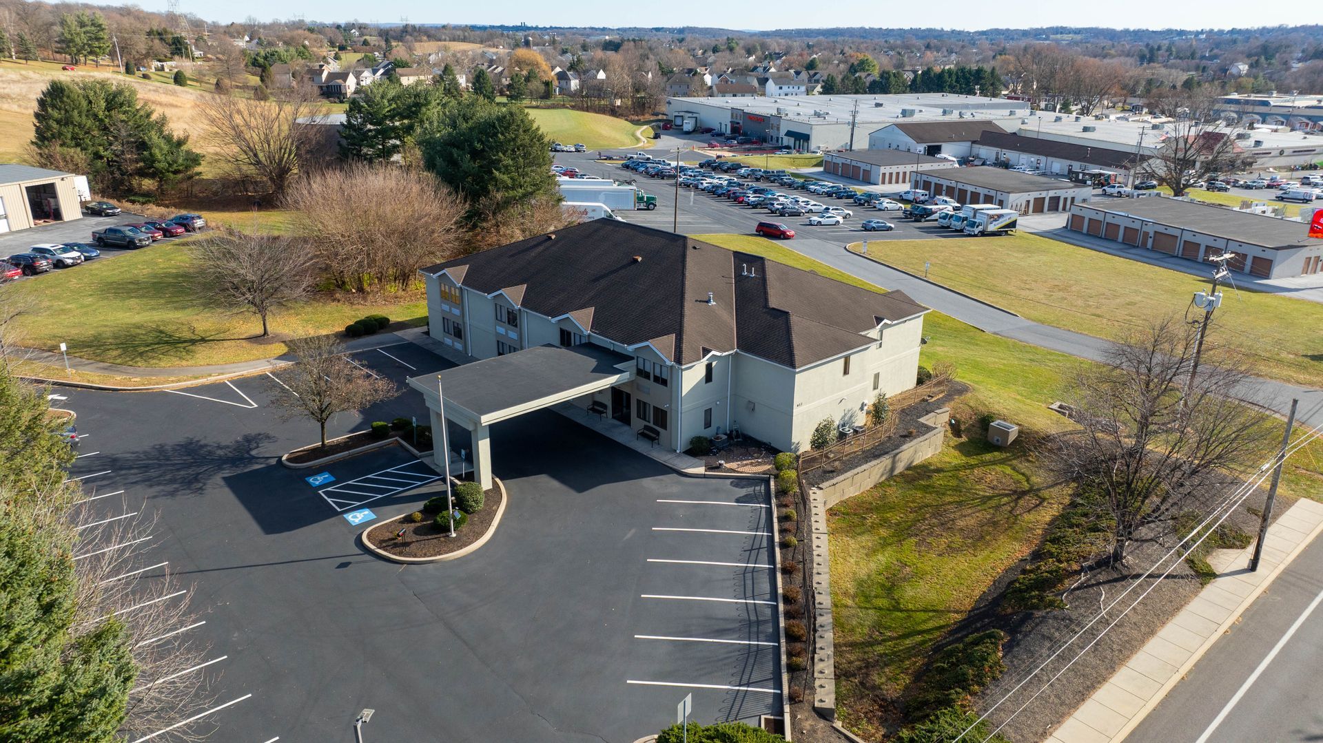 An aerial view of a hotel with a parking lot in front of it.