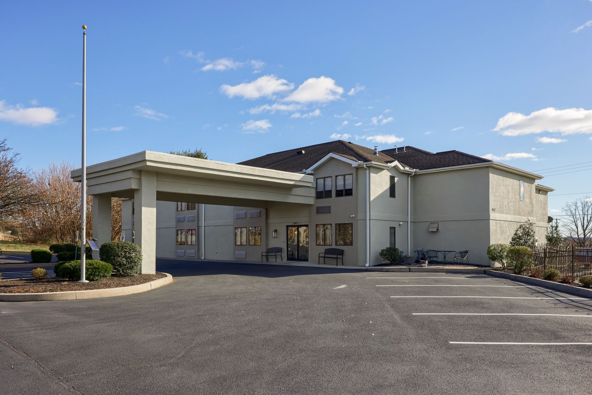 A large white building with a parking lot in front of it