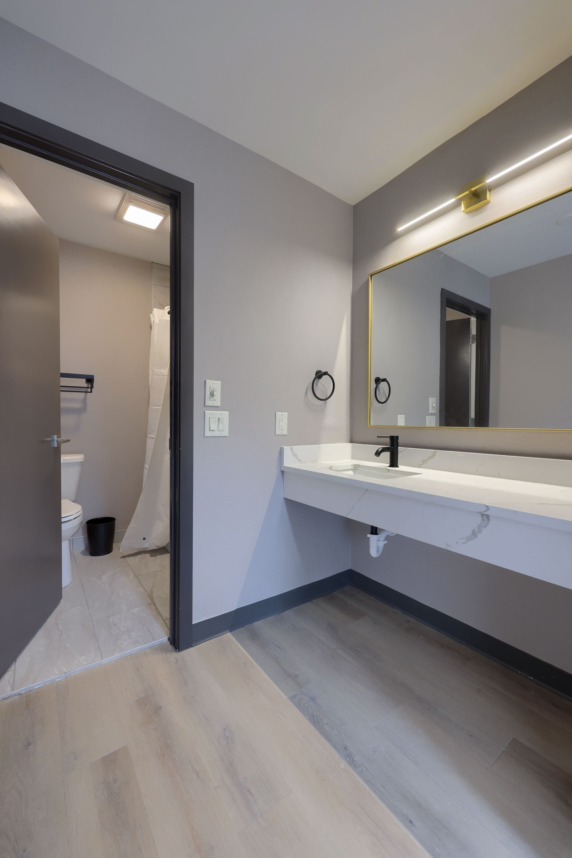 A bathroom with a sink , mirror and toilet.