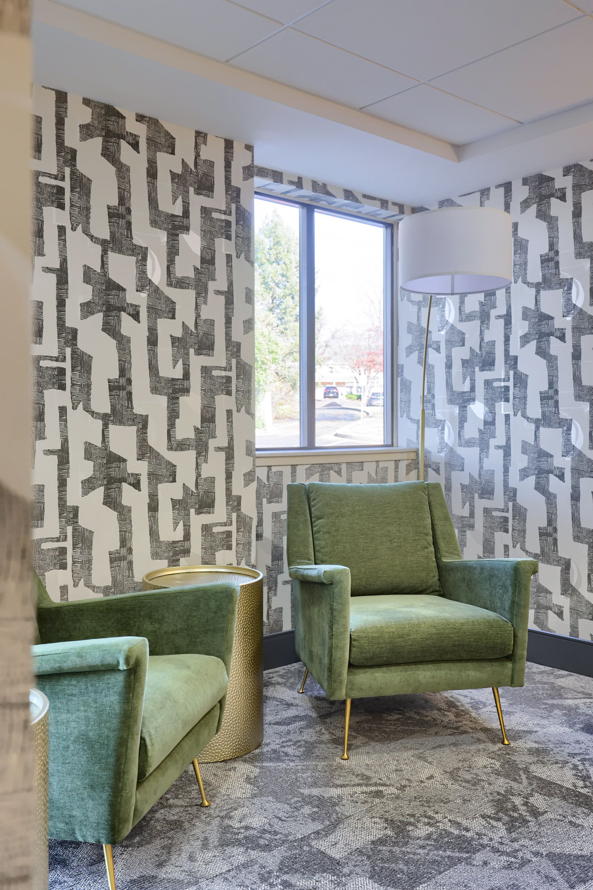 A living room with two green chairs and a couch.