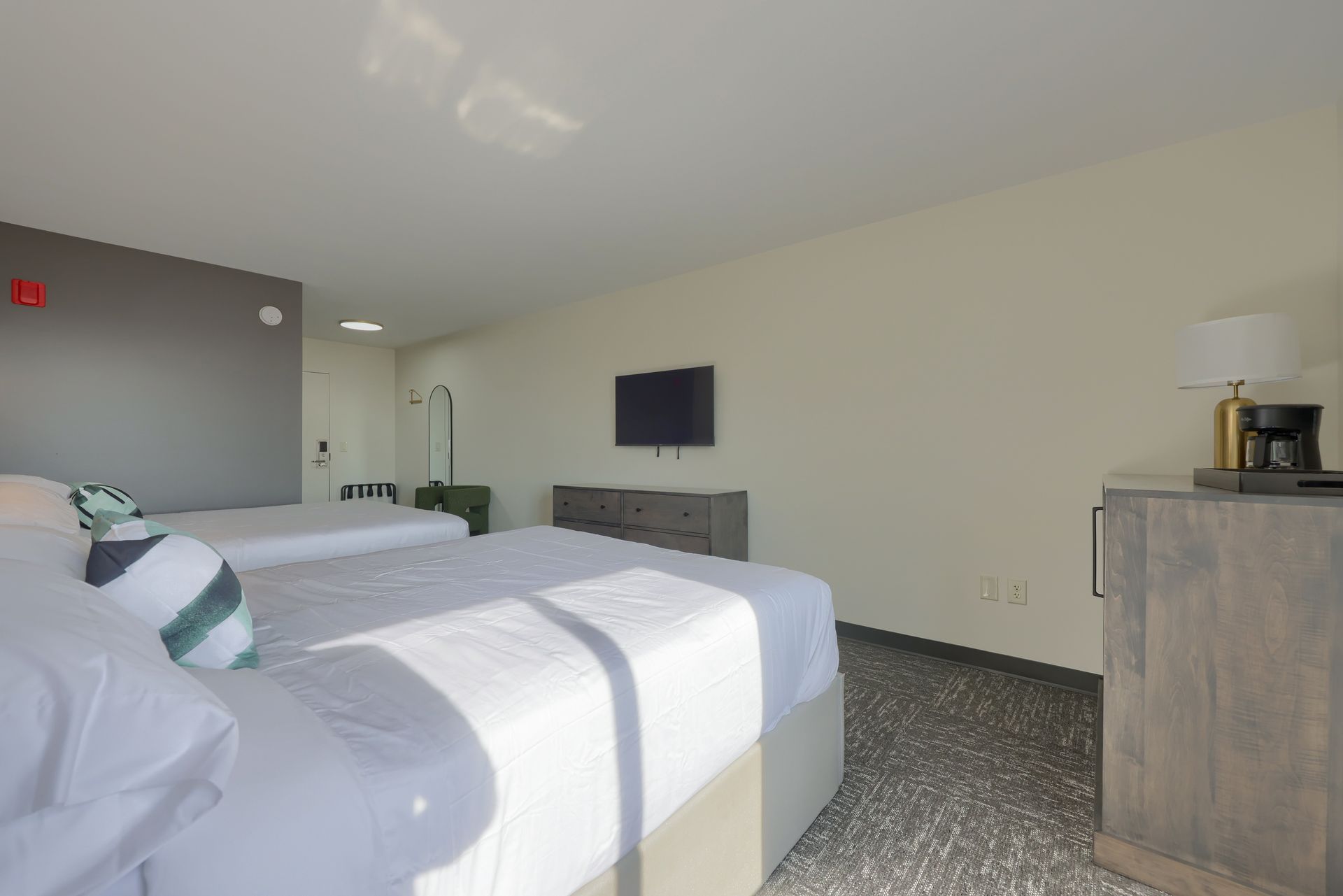 A hotel room with two beds and a flat screen tv.