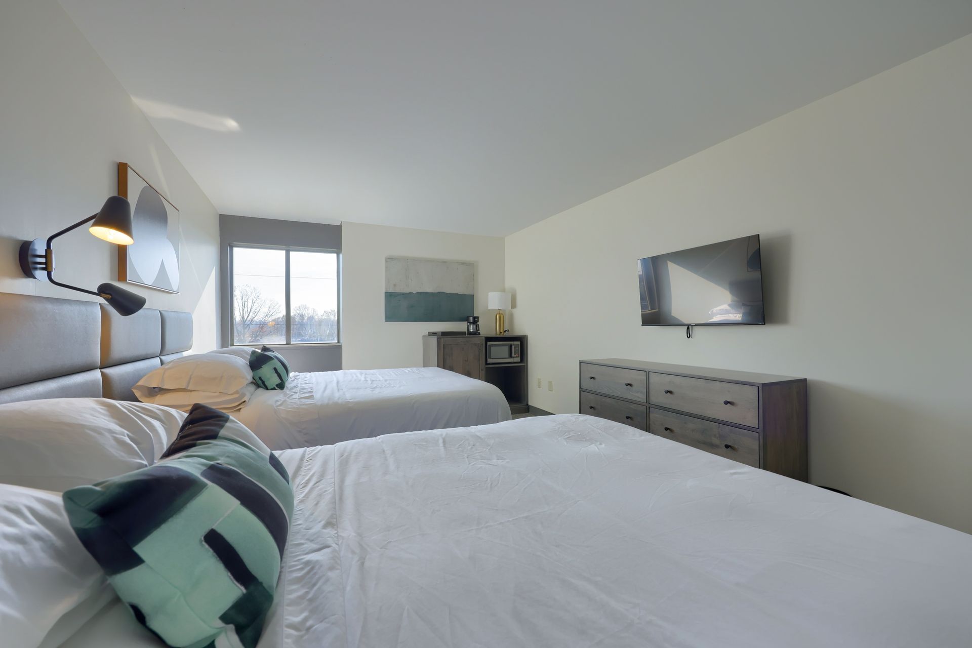 A hotel room with two beds and a flat screen tv.