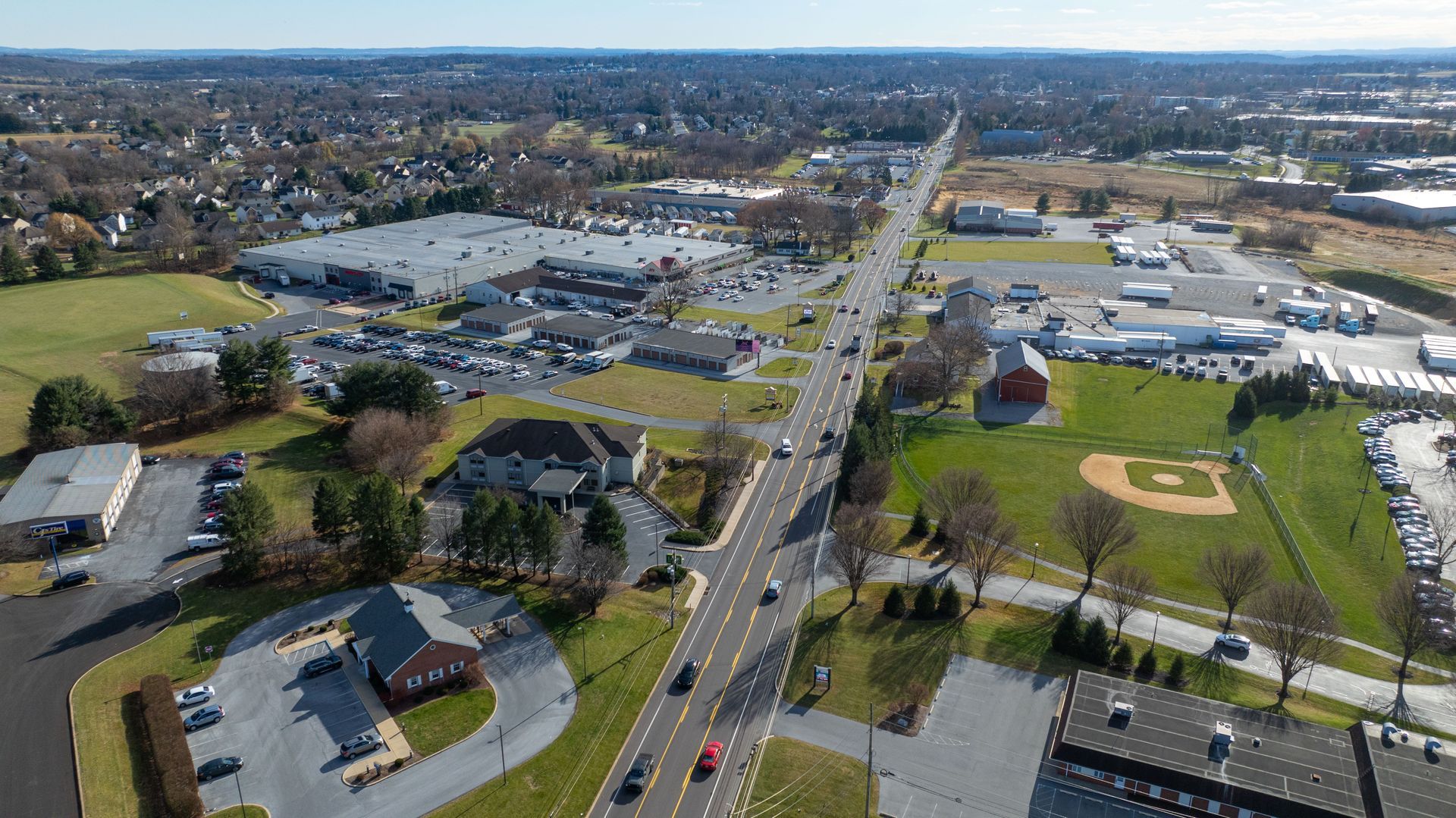An aerial view of a city with a baseball field in the middle of it.